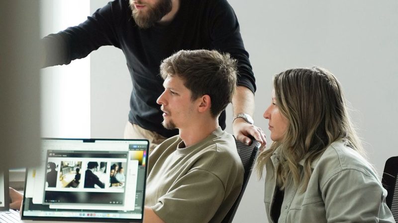 groupe de personne se concernant, concentré et parle devant un PC