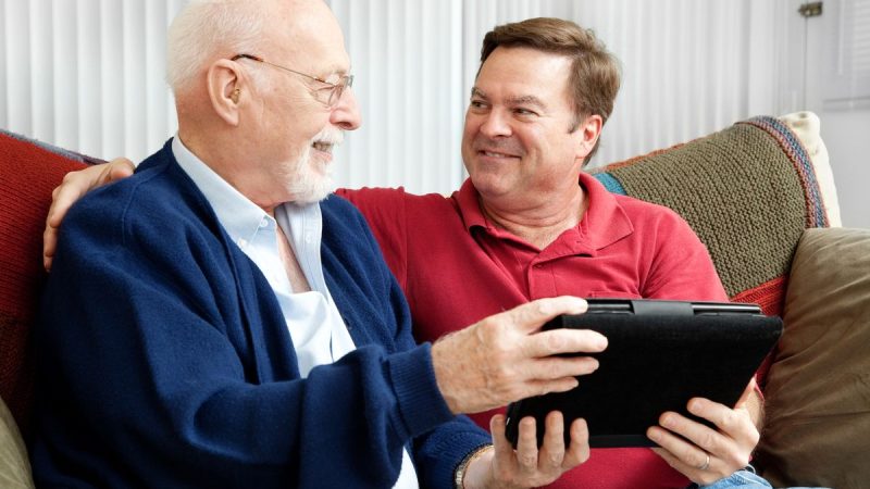 deux homme dont unaidant avec un utilsateur de Navia sur sa tablette