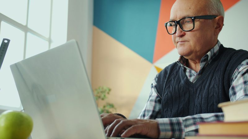 personnage agé concentré sur son ordinateur